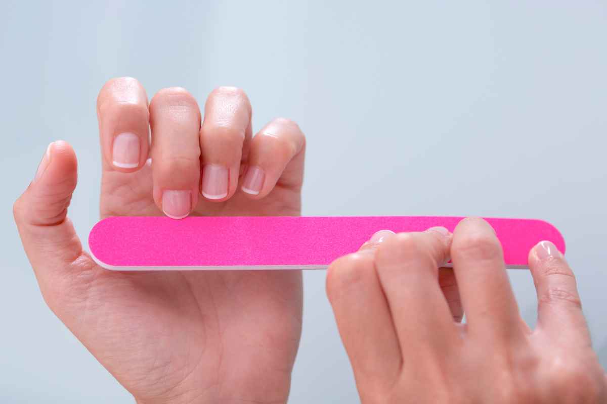 Vingernagels worden verzorgd met een roze kartonnen nagelvijl