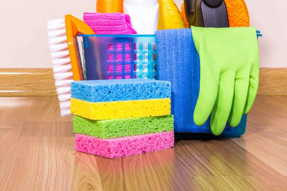 Mand met zachte doeken, handschoenen, sponzen en schoonmaakborstels